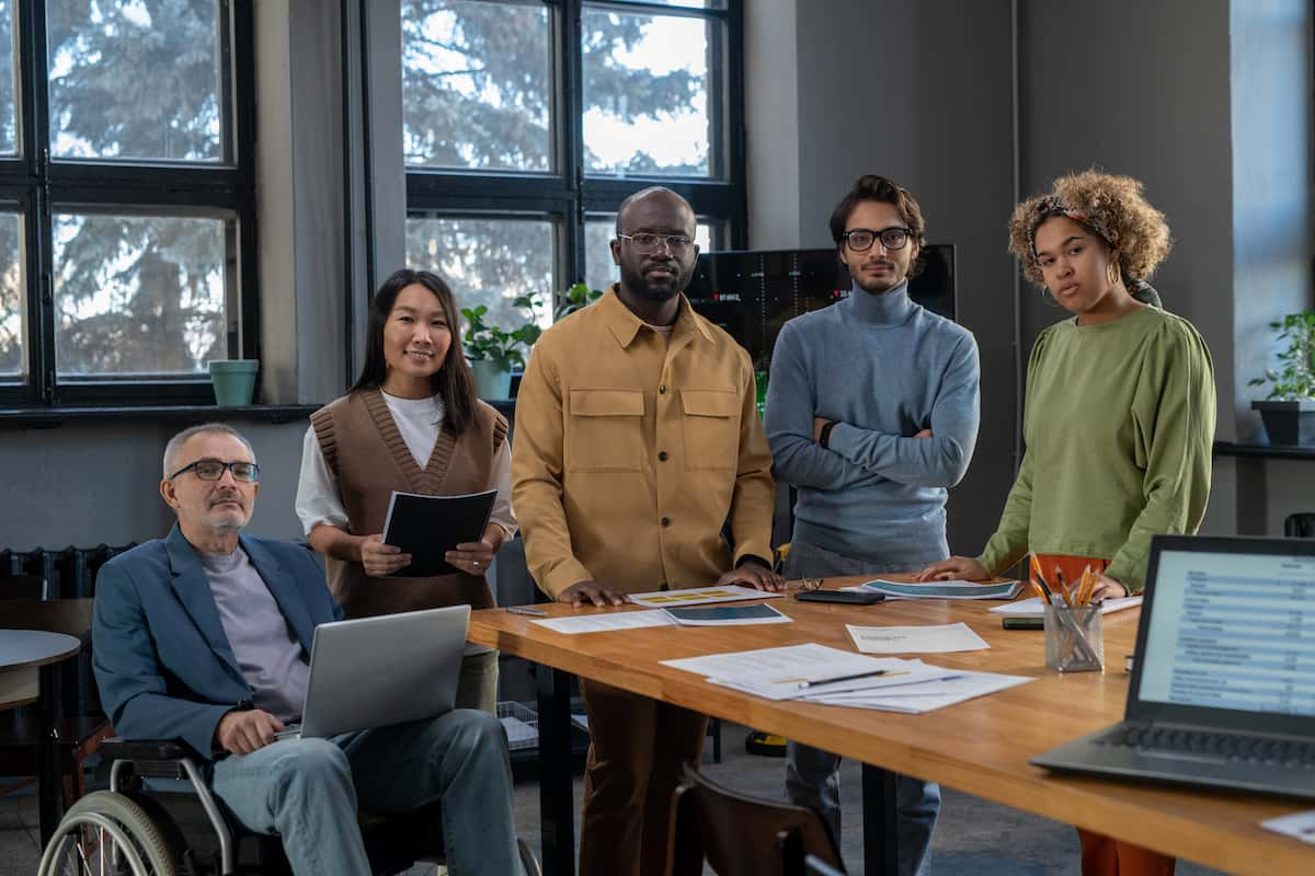 group of multiracial colleagues standing by table